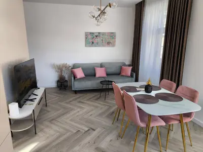 a living room with a couch and a table and chairs at Jaukus butas Šiaulių centre in Šiauliai