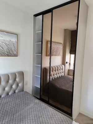 a bedroom with a mirror next to a bed at Jaukus butas Šiaulių centre in Šiauliai