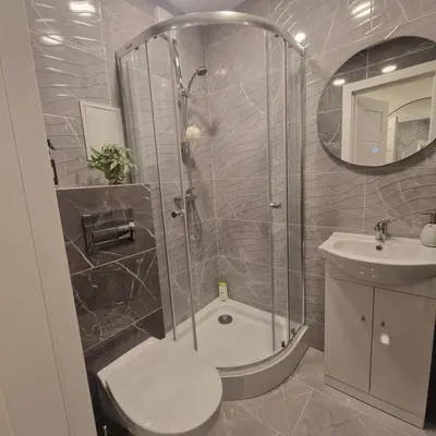 a bathroom with a shower and a toilet and a sink at Nauji centro apartamentai in Panevėžys