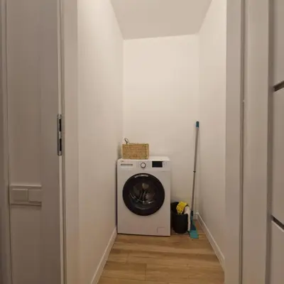 a washing machine in a laundry room with a door at Nauji centro apartamentai in Panevėžys