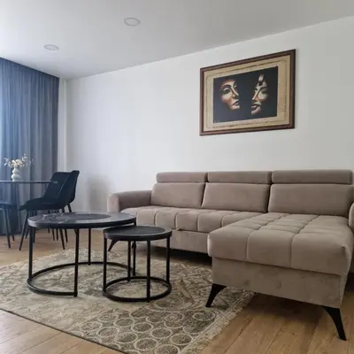 a living room with a couch and two tables at Nauji centro apartamentai in Panevėžys