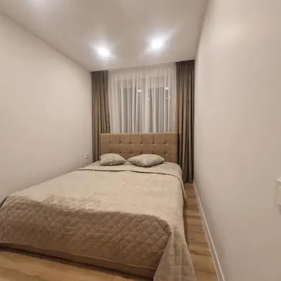 a bedroom with a bed in a white wall at Nauji centro apartamentai in Panevėžys