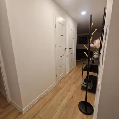 a room with a hallway with white walls and a mirror at Nauji centro apartamentai in Panevėžys