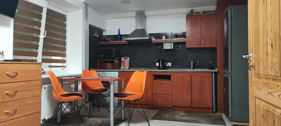 a kitchen with orange chairs and a table in it at Honey Apartament in Druskininkai