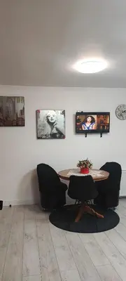 a room with a table and chairs and pictures on the wall at Honey Apartament in Druskininkai