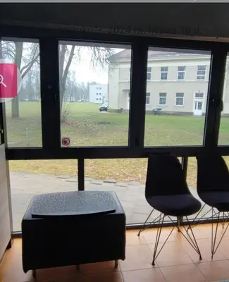 two chairs and a ottoman in front of a window at Honey Apartament in Druskininkai