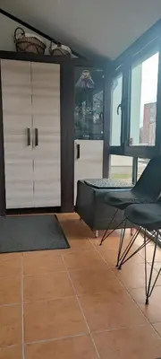 a bedroom with a bed and a chair at Amber Apartament in Druskininkai