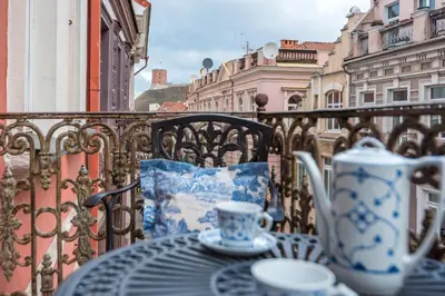 an iron balcony with a table and cups on it at Castle Street Retreat, 19 in Vilnius