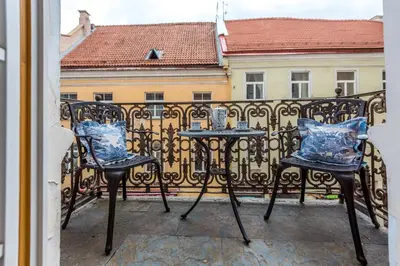 a balcony with two chairs and a table on a fence at Castle Street Retreat, 19 in Vilnius