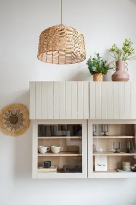 a white cabinet with dishes and a pendant light at Cozy & Stylish Loft near the city center in Vilnius