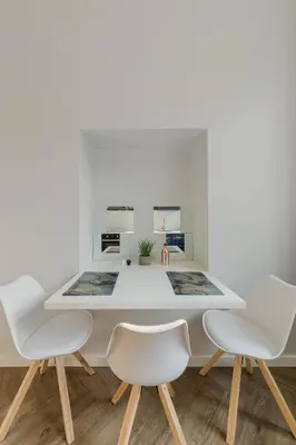 a dining room with a white table and chairs at Brand New Luxury Apartment, Parking, Center in Vilnius