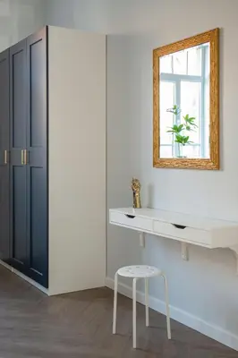 a white kitchen with a mirror and a stool at Brand New Luxury Apartment, Parking, Center in Vilnius