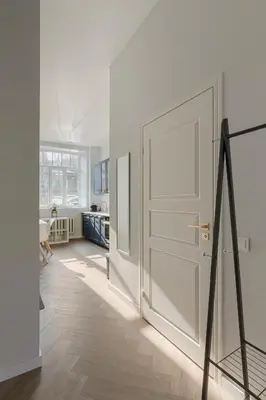 a white door in a white room with a table at Brand New Luxury Apartment, Parking, Center in Vilnius