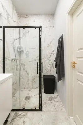 a shower with a glass door in a bathroom at Brand New Luxury Apartment, Parking, Center in Vilnius