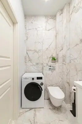a bathroom with a washing machine and a toilet at Brand New Luxury Apartment, Parking, Center in Vilnius