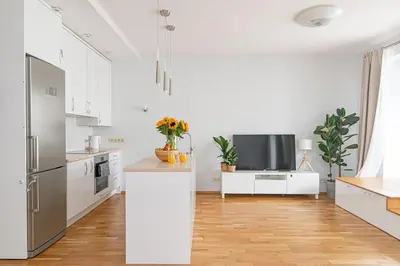 a kitchen with white cabinets and a tv on a counter at Bright 1 BDR apartment in Vivid Paupys by URBAN RENT in Vilnius