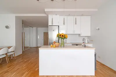 a kitchen with white cabinets and a vase of flowers on a counter at Bright 1 BDR apartment in Vivid Paupys by URBAN RENT in Vilnius
