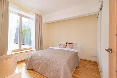 a bedroom with a bed and a large window at Bright 1 BDR apartment in Vivid Paupys by URBAN RENT in Vilnius