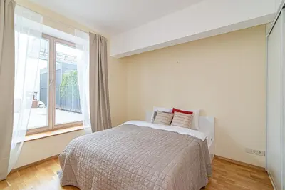 a bedroom with a bed and a large window at Bright 1 BDR apartment in Vivid Paupys by URBAN RENT in Vilnius