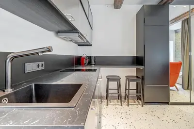 a kitchen with a sink and a counter with stools at Vilnius city, 17 FREE Street Parking in Vilnius