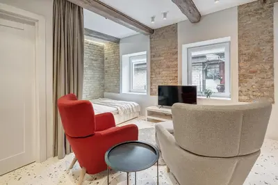 a living room with a red chair and a bed at Vilnius city, 17 FREE Street Parking in Vilnius