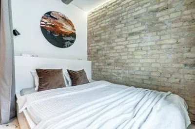 a bedroom with a brick wall and a bed at Vilnius city, 17 FREE Street Parking in Vilnius
