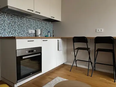 a kitchen with a stove and two chairs in it at Maslow apartments - Self check in in VNO