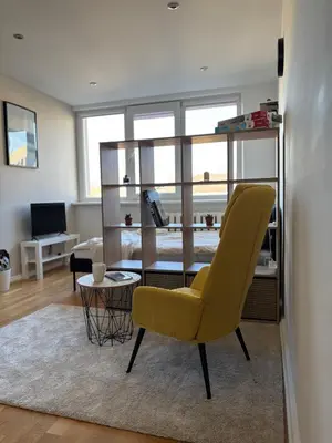 a living room with a yellow chair and a table at Maslow apartments - Self check in in VNO
