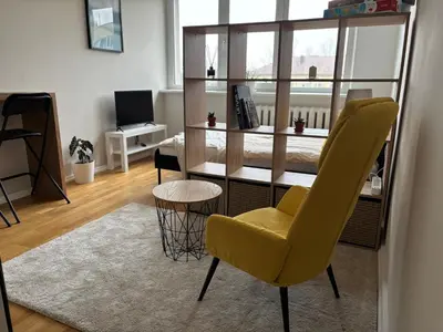 a living room with a yellow chair and a table at Maslow apartments - Self check in in VNO