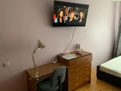 a bedroom with a desk and a dresser with a tv on the wall at Minties apartment in Vilnius