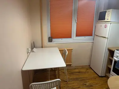 a kitchen with a white table and a refrigerator at Minties apartment in Vilnius
