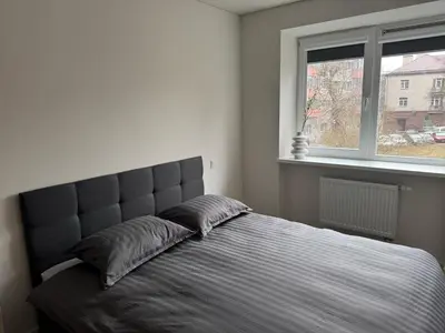 a bedroom with a large bed with a window at STAR apartamentai in Panevėžys