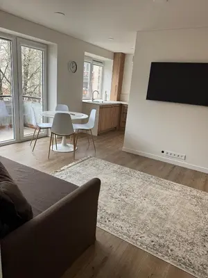 a living room with a couch and a tv on a wall at STAR apartamentai in Panevėžys