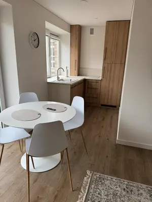 a kitchen with a white table and chairs in a room at STAR apartamentai in Panevėžys