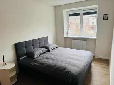 a bedroom with a large bed with a window at STAR apartamentai in Panevėžys