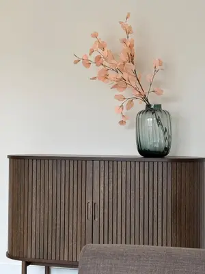 a vase with flowers in it sitting on top of a cabinet at STAR apartamentai in Panevėžys