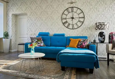 a blue couch in a living room with a clock on the wall at Old Town Apartment Free parking in Vilnius