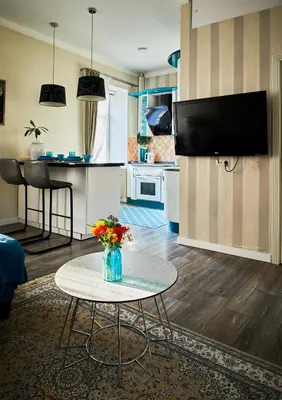 a living room with a table and a kitchen at Old Town Apartment Free parking in Vilnius