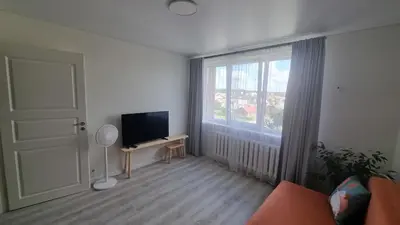 a living room with a television and a window at Tiny cozy apartment 'Unihus' in Varėna