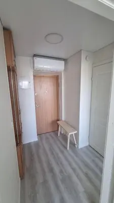 an empty room with a wooden door and a bench at Tiny cozy apartment 'Unihus' in Varėna