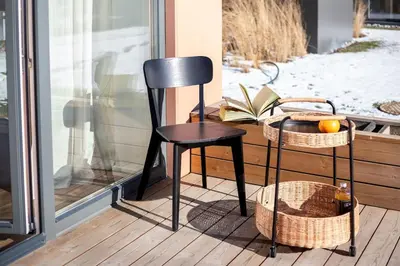 a black chair sitting on a porch with baskets at Sunny, Peaceful & Spacious Apartment by URBAN RENT in Vilnius