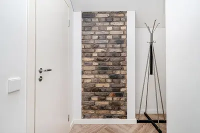 a room with a brick wall next to a door at Timeless Bliss Old Town Apartment by Reside Baltic in Vilnius