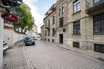 a car parked on a cobblestone street next to buildings at Timeless Bliss Old Town Apartment by Reside Baltic in Vilnius