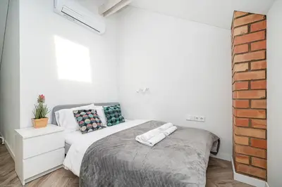 a bedroom with a bed and a brick wall at Timeless Bliss Old Town Apartment by Reside Baltic in Vilnius