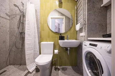 a bathroom with a toilet and a sink and a washing machine at Timeless Bliss Old Town Apartment by Reside Baltic in Vilnius