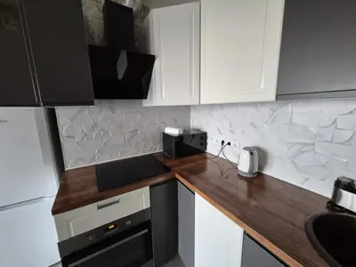 a kitchen with white cabinets and a wooden counter top at Gilužio Apartments in Vilnius