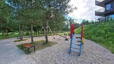 a park with a playground with swings and a bench at Gilužio Apartments in Vilnius