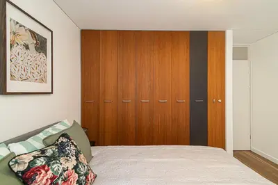 a bedroom with a bed and a wooden cabinet at Stylish & Comfortable 1-Bedroom Apartment in Vilnius Old Town by URBAN RENT in Vilnius