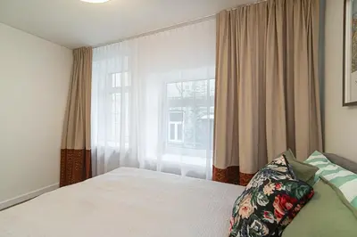 a bedroom with a bed and a large window at Stylish & Comfortable 1-Bedroom Apartment in Vilnius Old Town by URBAN RENT in Vilnius