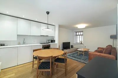 a kitchen and living room with a table and a couch at Stylish & Comfortable 1-Bedroom Apartment in Vilnius Old Town by URBAN RENT in Vilnius